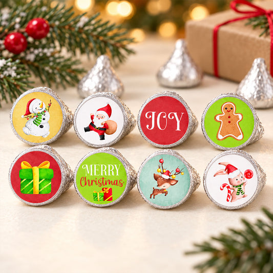Christmas candy stickers on silver-wrapped chocolates beside evergreen branches, red berries, and a wrapped gift
