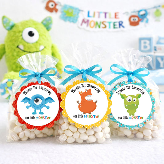 Three bags of candy with colorful monster-themed labels and a green monster toy in the background.