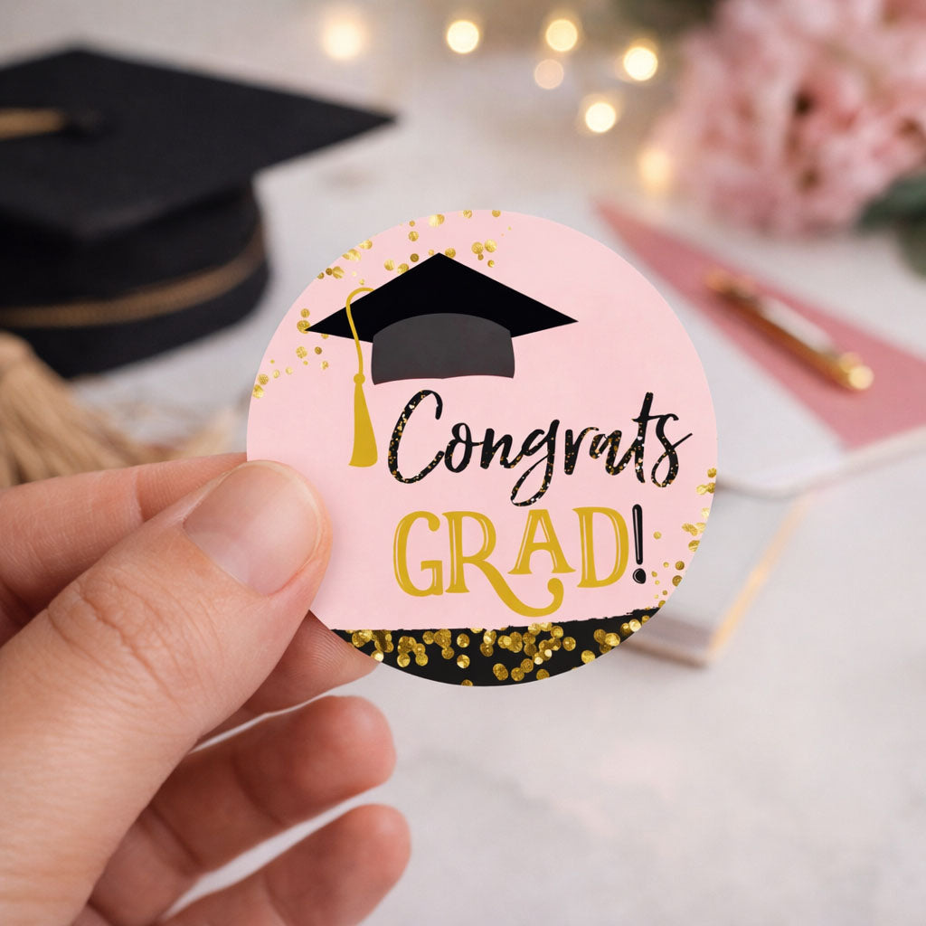 hand holding pink black and gold graduation sticker label