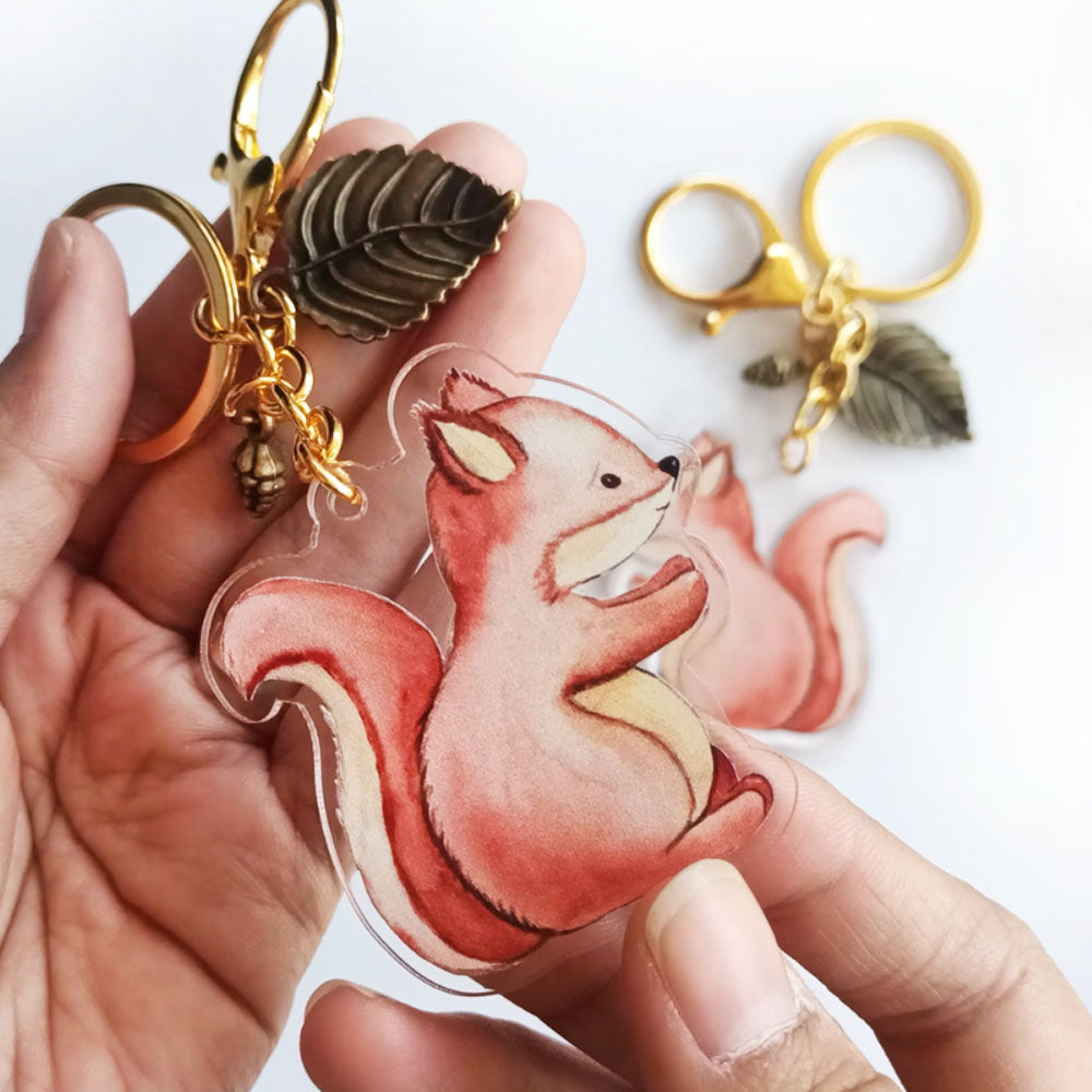 Cute squirrel acrylic keychain charm held in hand with gold clasp and leaf charm woodland animal accessory