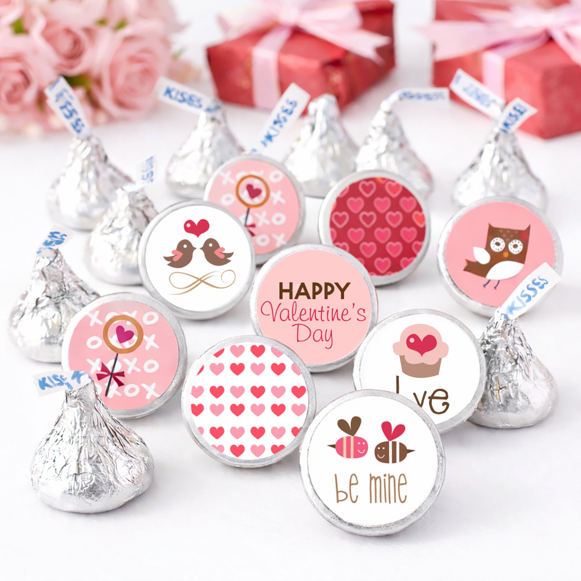 Valentine's Day themed candy kiss sticker labels for Hershey's Kisses on a white background with pink flowers and red gift boxes.