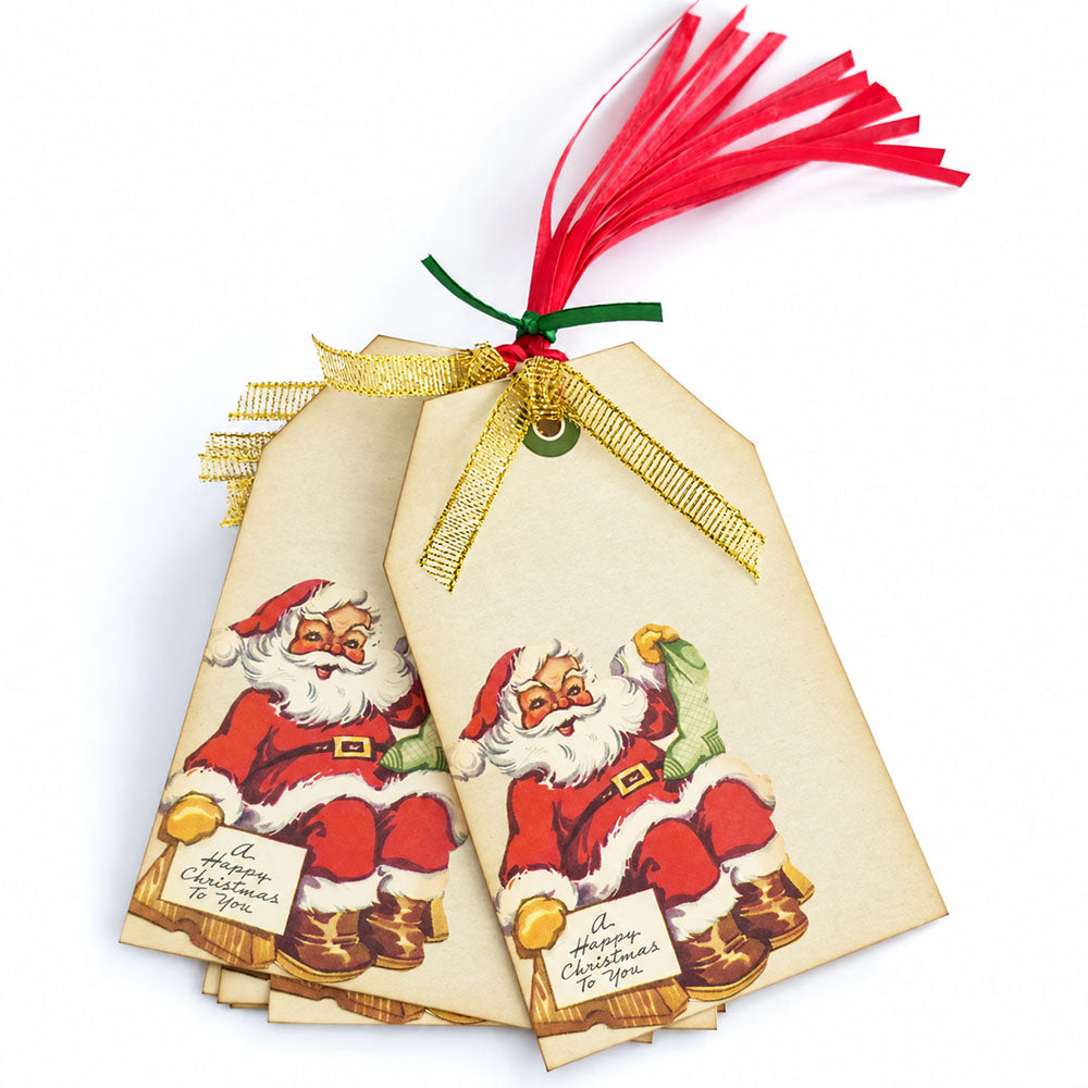 Vintage Santa Christmas gift tags arranged together with gold ribbons, red ribbon strands, and a green tie