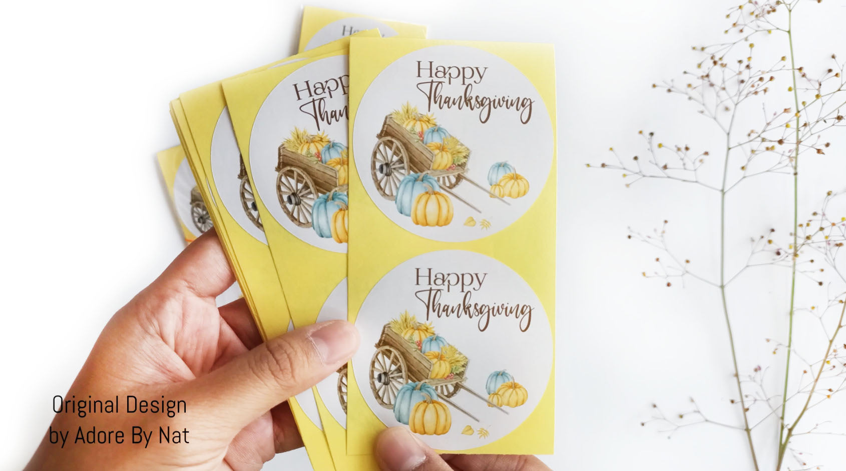 Set of Thanksgiving stickers held in hand, showing multiple 2.5 inch round labels with watercolor pumpkin design.