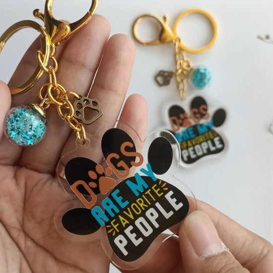 Dog lover gift keychain with acrylic paw charm, blue globe and gold clasp attachment
