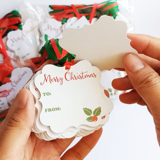 Close-up view of Merry Christmas holiday gift tags with red and green ribbons for festive wrapping