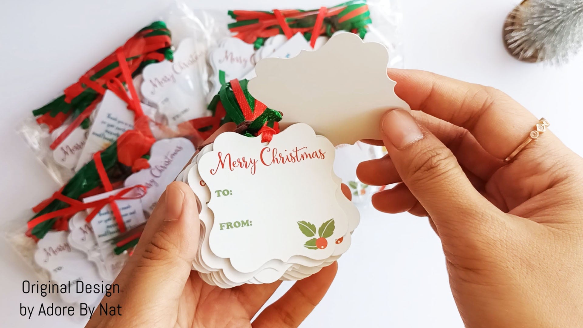 Close-up view of Merry Christmas holiday gift tags with red and green ribbons for festive wrapping