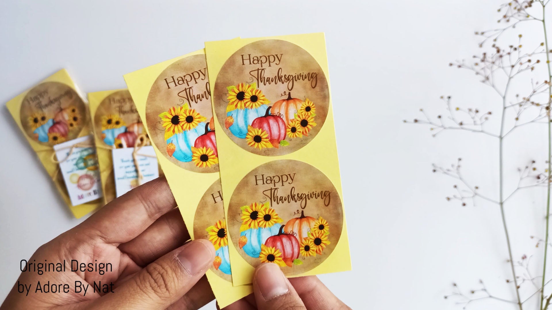 Hand showing rustic pumpkin and sunflower Thanksgiving stickers for fall party favors